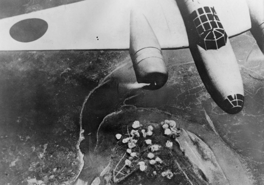 Японский бомбардировщик в полете 14 сентября 1940 года. Ниже дым поднимается из группы бомб, сброшенных на Чунцин, Китай, недалеко от излучины реки Янцзы.