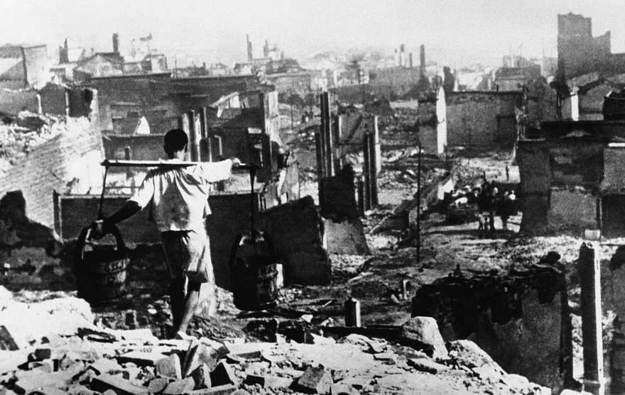 Не имея ничего, кроме опустошения, с которым он столкнулся, этот китайский водонос все еще продолжал трудиться после четырех дней и ночей воздушной бомбардировки японскими военными самолетами в Чунцине, Китай, 10 августа 1940 года.