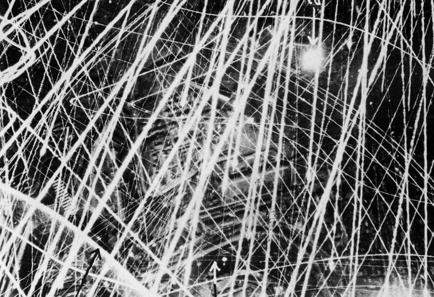 Эта фотография была сделана 31 января 1941 года во время ночных воздушных налетов Королевских ВВС над Брестом, Франция. Это дает графическое представление о том, как зенитный огонь выглядит с воздуха. В течение трех-четырех секунд, в течение которых затвор оставался открытым, камера четко уловила яростный выстрел. Тонкие линии света показывают пути следов снарядов, а более широкие линии - пути более тяжелых орудий. Фабрики и другие здания можно увидеть ниже.