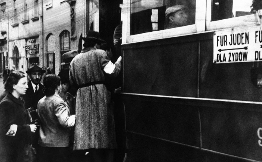 Сцена из Варшавского гетто, где 17 февраля 1941 года видны евреи в белых нарукавных повязках со звездой Давида и трамваи с пометкой «Только для евреев».