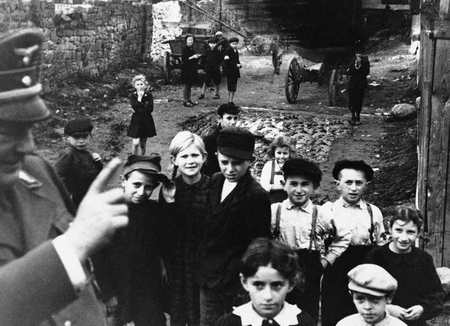Офицер немецкой армии читает лекции детям в гетто в Люблине, оккупированной Германией Польше, в декабре 1940 года, говоря им: «Не забывайте мыться каждый день».